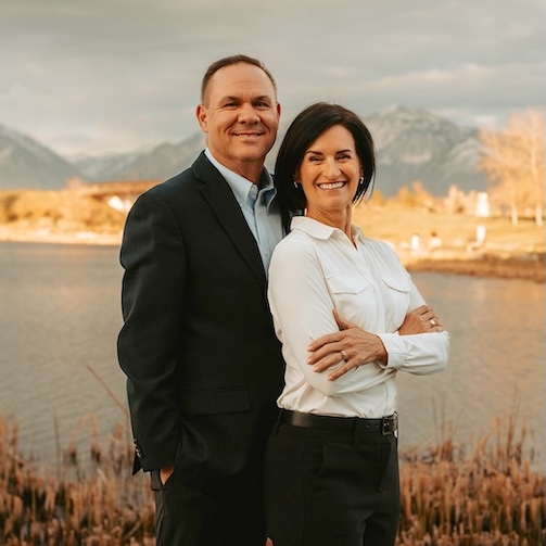 Tamara and Corey Zander standing together beside Oquirrh Lake in Daybreak, South Jordan, Utah