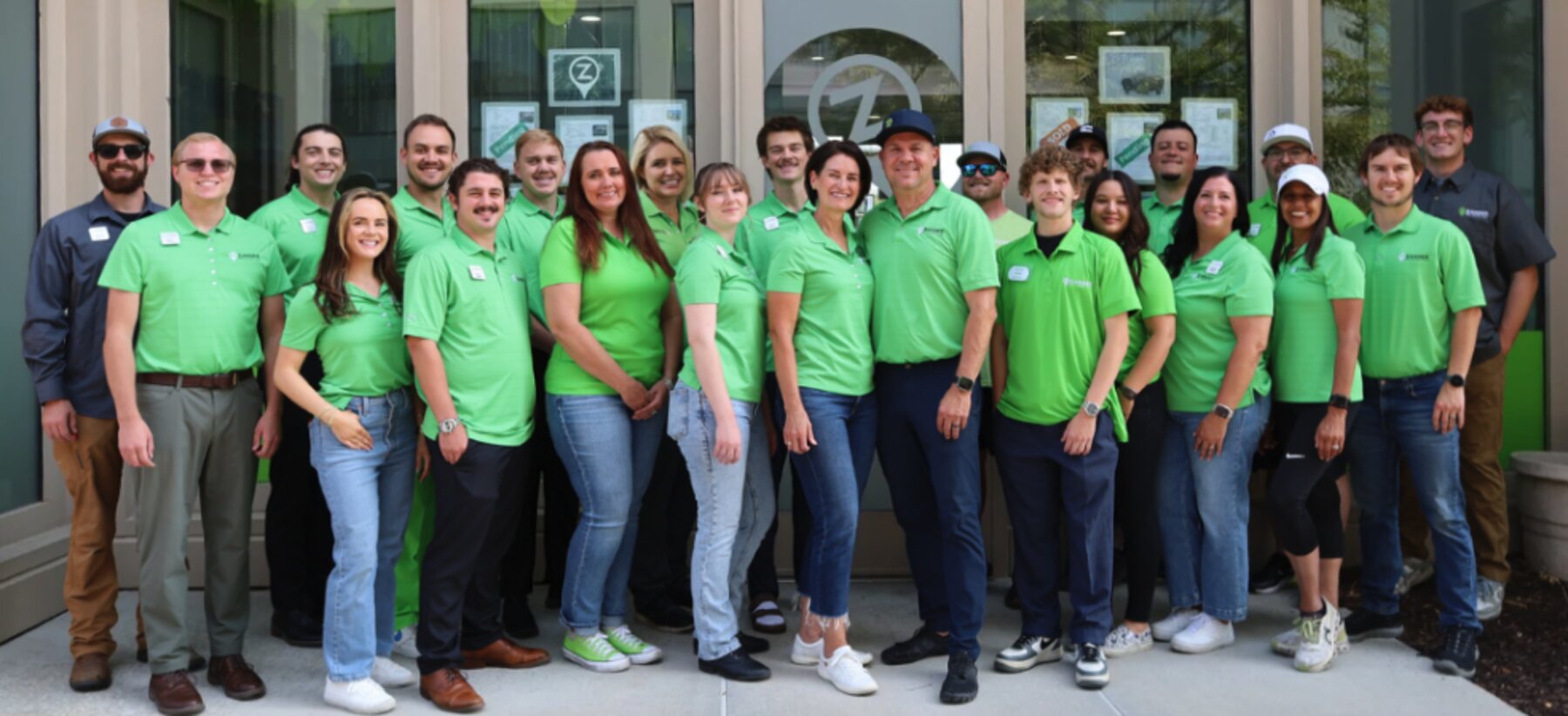 The Zander Real Estate Team standing together outside their Daybreak, South Jordan office at SoDa Row